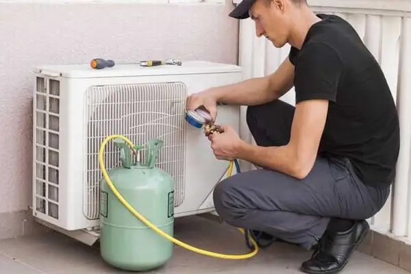teknisi sedang cek tekanan freon ac