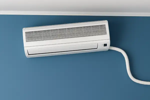 instalasi air conditioner tipe split terpasang miring di dinding rumah, contoh pemasangan yang salah dan membutuhkan jasa bongkar pasang AC profesional untuk perbaikan