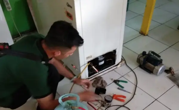 teknisi service freezer sedang melakukan pengecekan pada freezer yang bermasalah