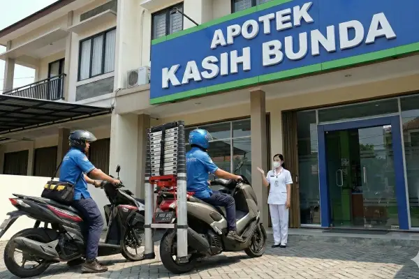 Teknisi membawa tangga lipat tiba di Apotek Kasih Bunda untuk melakukan perawatan AC apotek profesional.