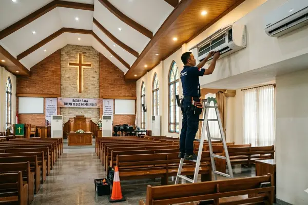 Teknisi sedang melakukan Service AC Gereja